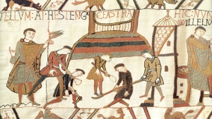 A scene from the Bayeux Tapestry showing the Normans building a castle. Note how the different coloured stiching indicates layers of different materials being used in the construction.