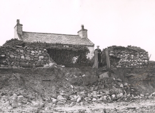 A resident at Cranstal surveys the damage after an easterly gale. His house and those of his neighbours were all claimed by the sea in the 1950s.